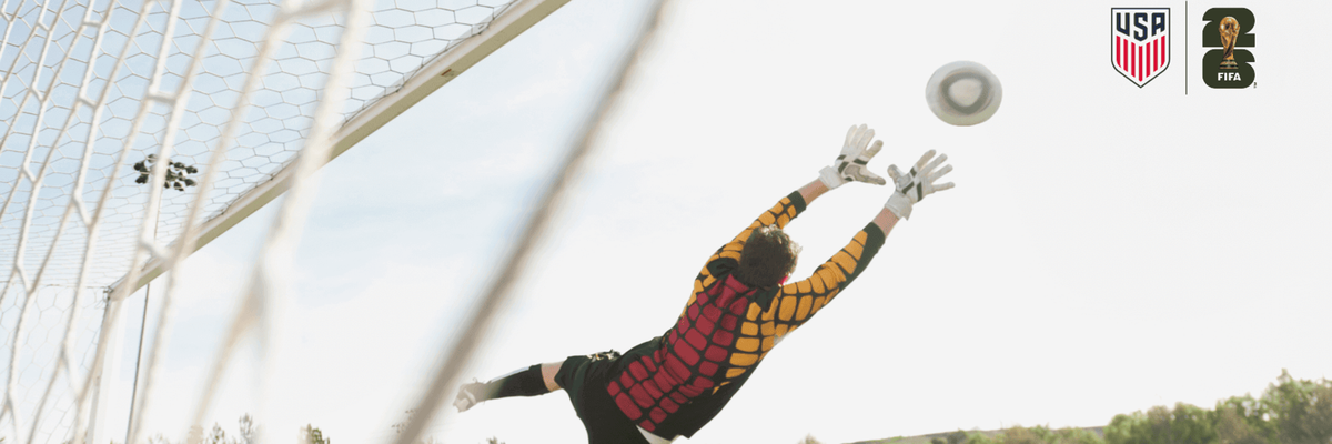 Player saving a goal as the other player kicks the ball while playing soccer