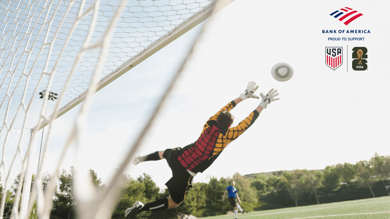 Player saving a goal as the other player kicks the ball while playing soccer
