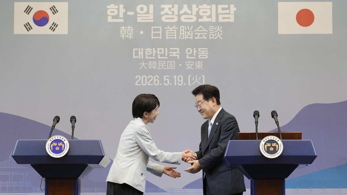 PM Takaichi and President Lee Jae Myung shaking hands at a press event