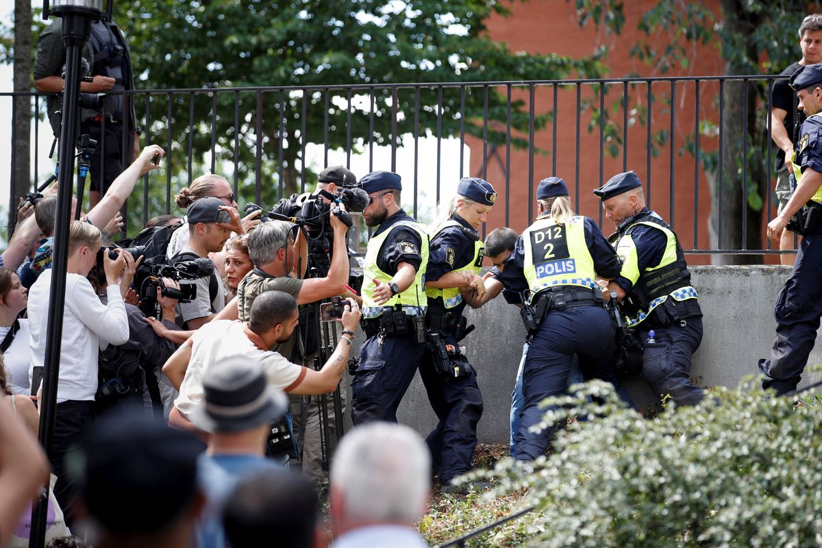 Police officers intervene amid demonstrations over the burning of the Koran outside Stockholm's central mosque.