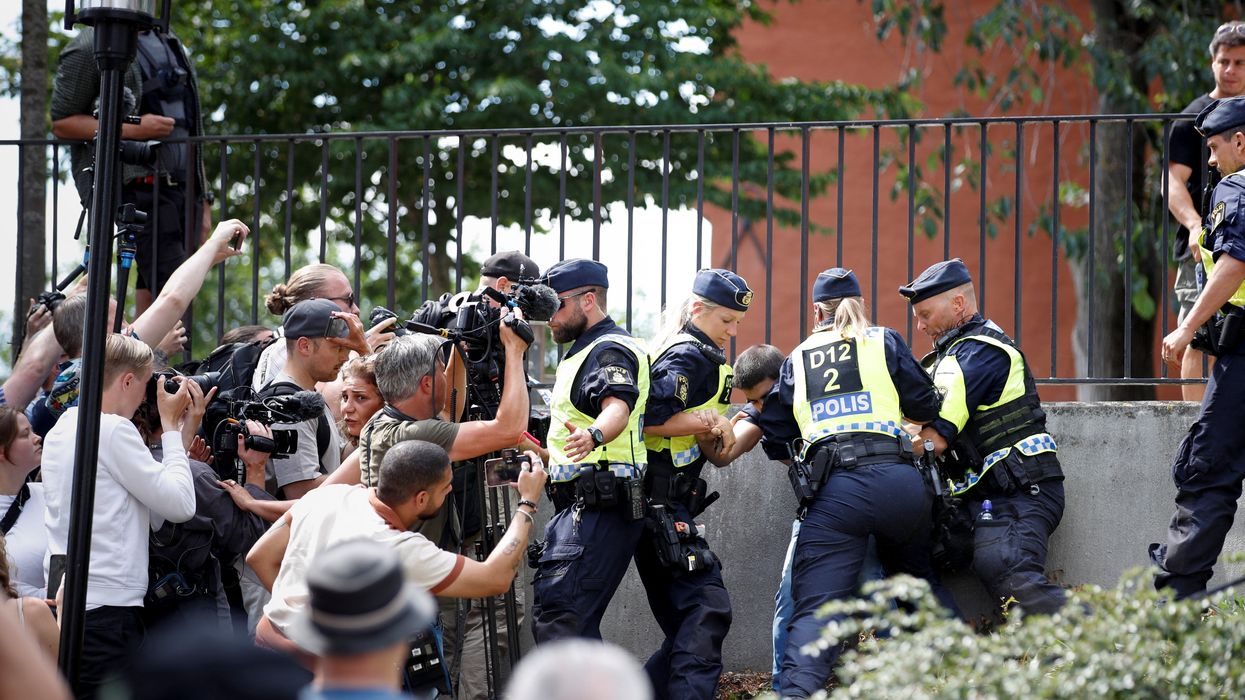 Police officers intervene amid demonstrations over the burning of the Koran outside Stockholm's central mosque.