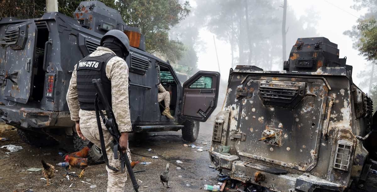 Police officers pass a burnt police armoured personnel carrier after gunmen kidnapped several people from an orphanage in a mountainous community that has been under deadly attacks by armed gangs since the start of this year, on the outskirts of Port-au-Prince, in Kenscoff, Haiti August 4, 2025.
