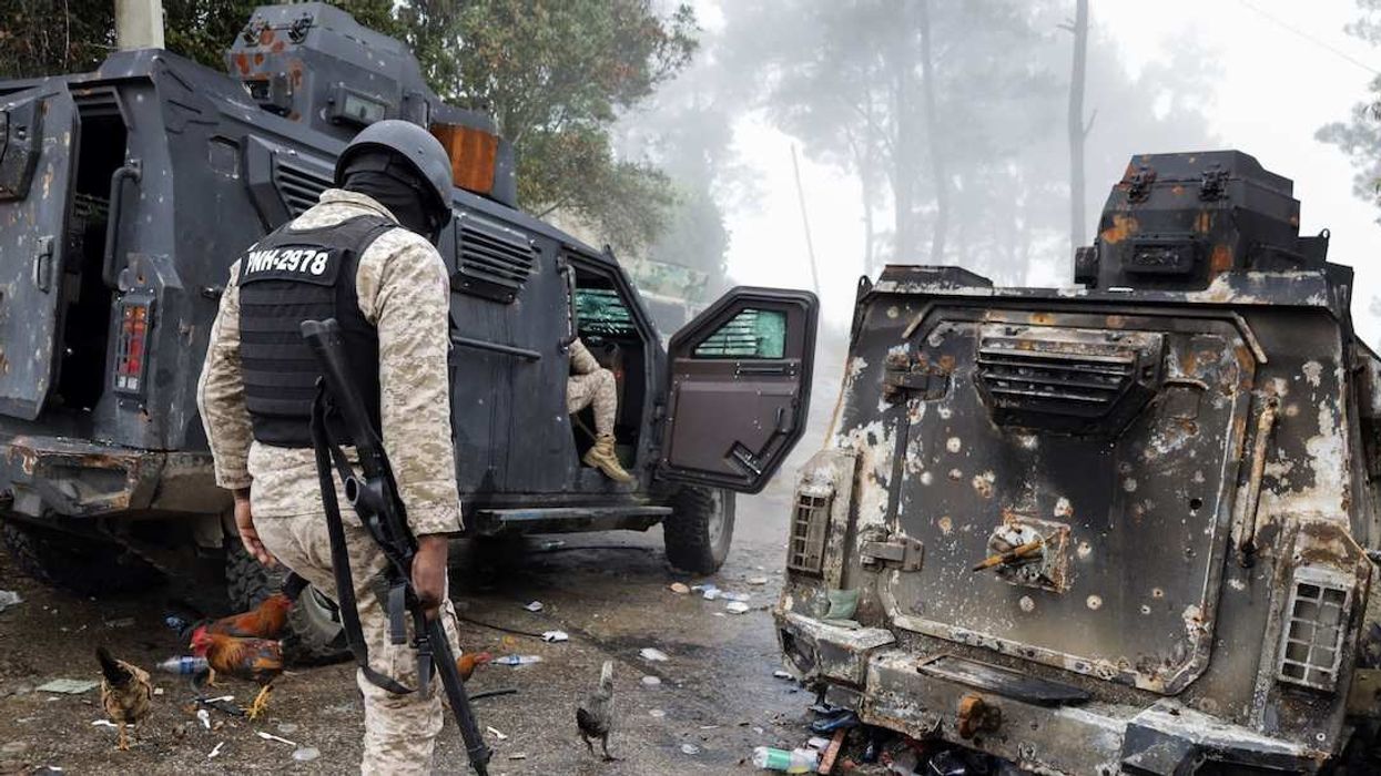 Police officers pass a burnt police armoured personnel carrier after gunmen kidnapped several people from an orphanage in a mountainous community that has been under deadly attacks by armed gangs since the start of this year, on the outskirts of Port-au-Prince, in Kenscoff, Haiti August 4, 2025.