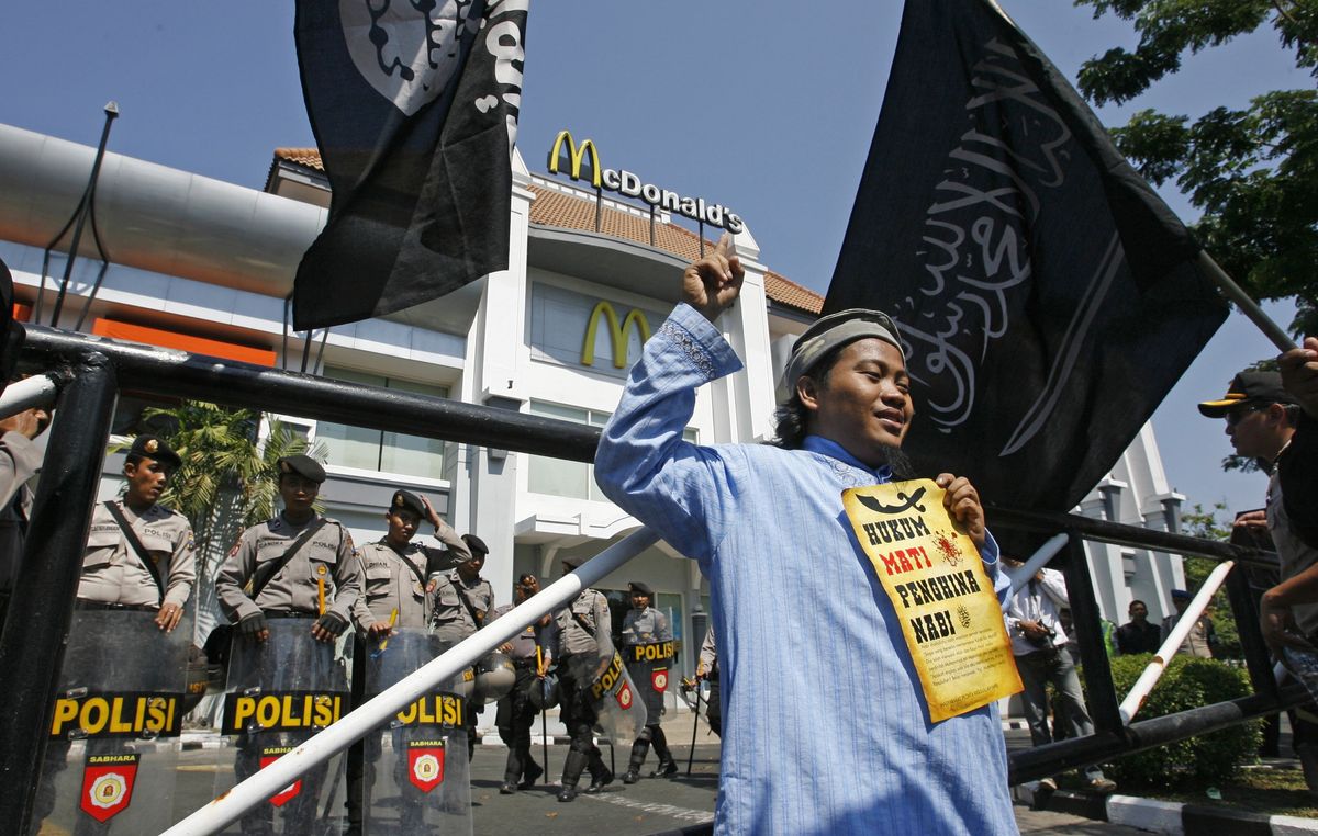 ​Police officers stand guard outside a McDonald's restaurant during a protest.  