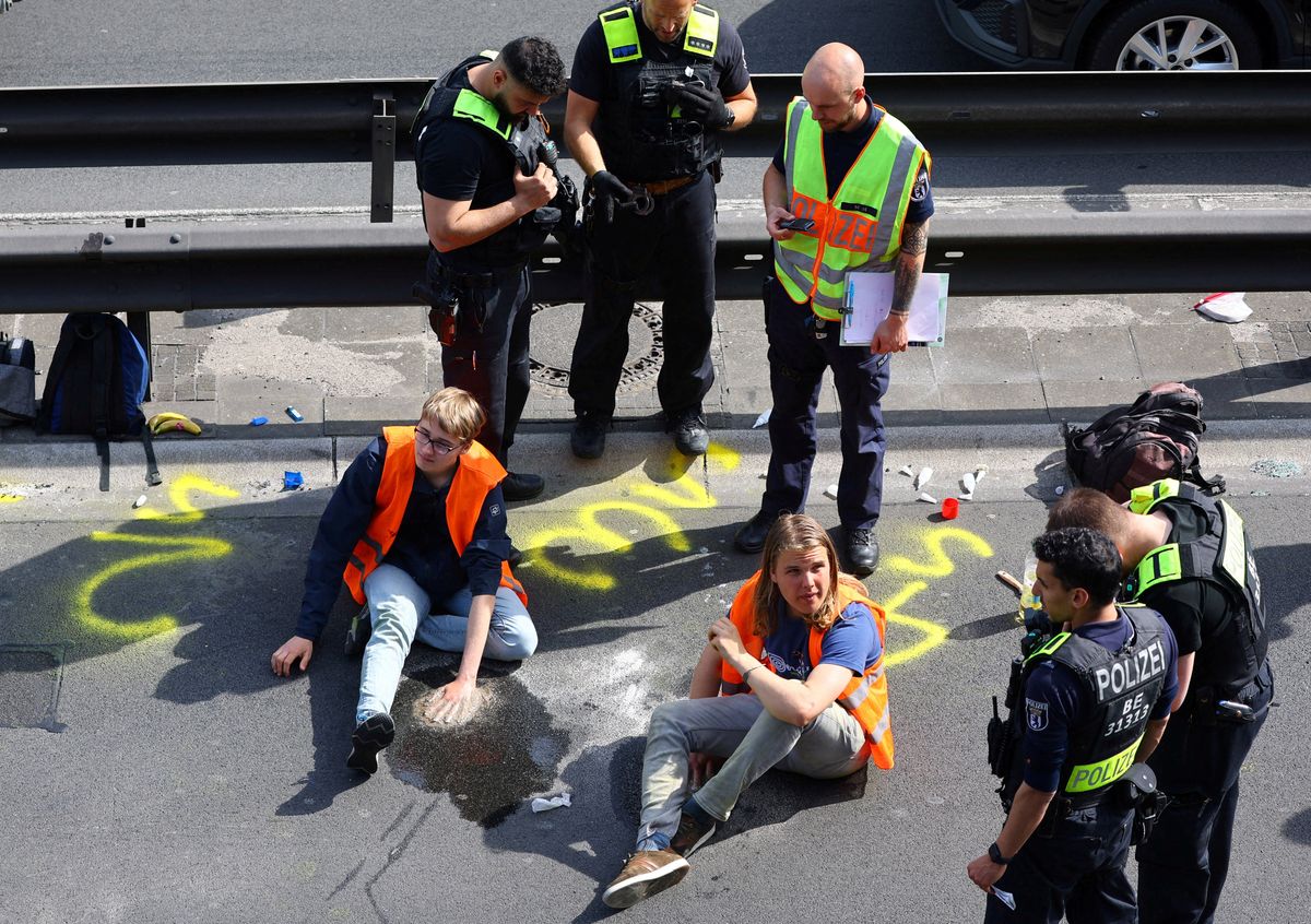 Police surround activists of the "Letzte Generation" (Last Generation) after they glued their hands on asphalt