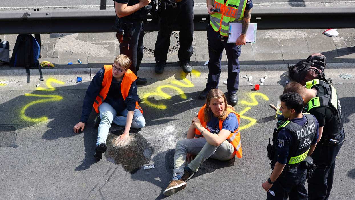 Police surround activists of the "Letzte Generation" (Last Generation) after they glued their hands on asphalt