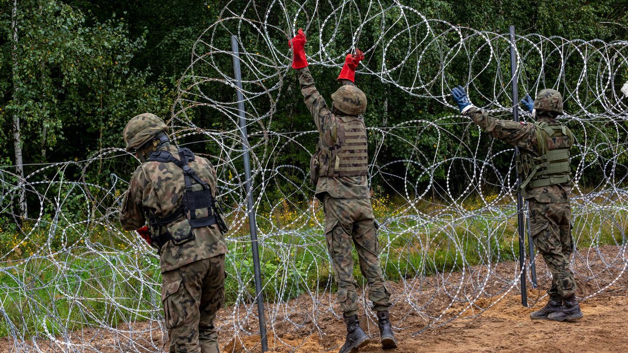 Polish Army Soldiers build a fence with concertina wire at the Belarusian border in order to stop immigrants from entering the country in Krynki, Poland on 27 August, 2021.
