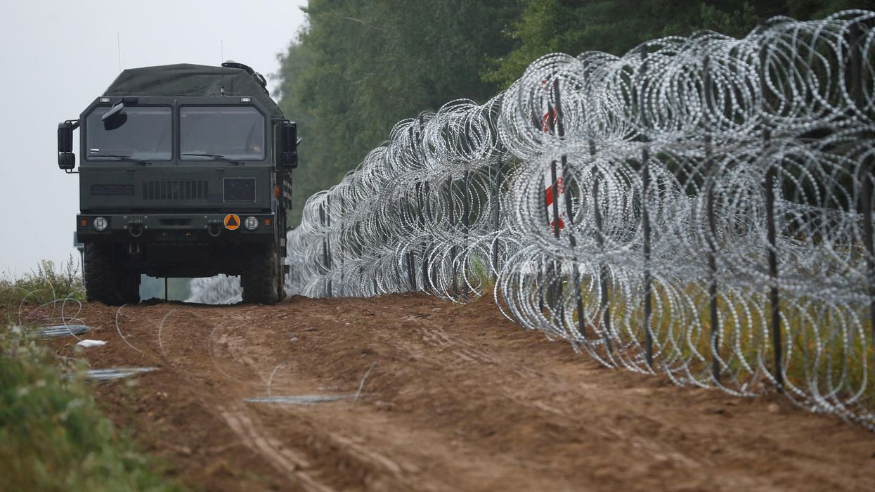 Polish soldiers build a fence on the border between Poland and Belarus near the village of Nomiki.
