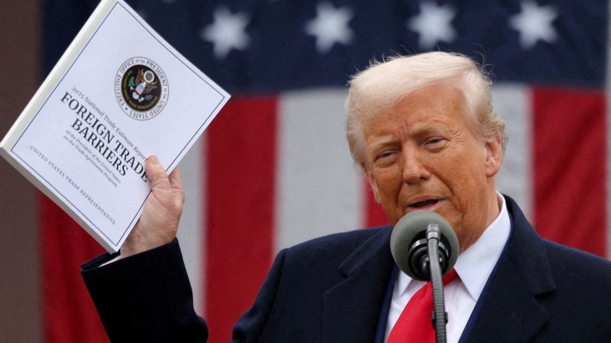 President Donald Trump holds a "Foreign Trade Barriers" document as he delivers remarks on tariffs in the Rose Garden at the White House on April 2, 2025.