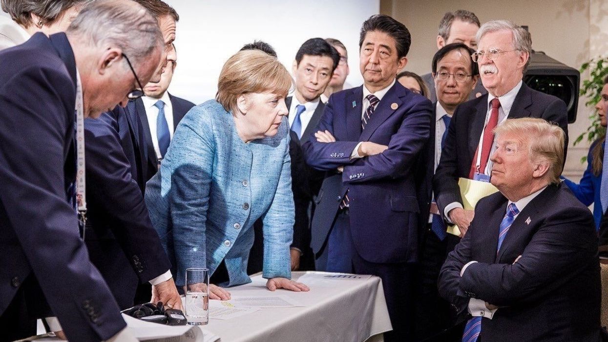 President Donald Trump seated surrounded by foreign leaders including Germany's Angela Merkel, Japan's Shinzo Abe and France's Emmanuel Macron