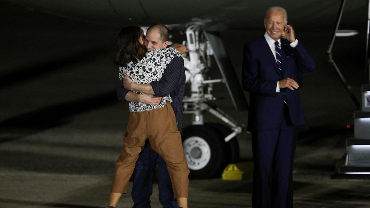 President Joe Biden looks on as Evan Gershkovich, who was released from detention in Russia, is greeted by his mother Ella Milman, upon his arrival at Joint Base Andrews in Maryland, on Aug. 1, 2024.