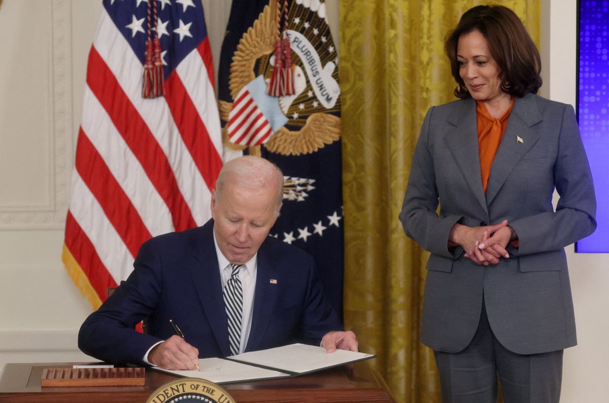 President Joe Biden signs an executive order about artificial intelligence as Vice President Kamala Harris looks on at the White House on Oct. 30, 2023. 