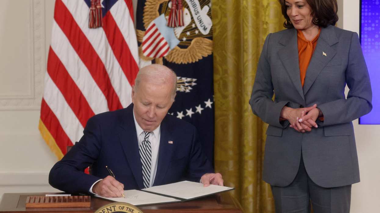 President Joe Biden signs an executive order about artificial intelligence as Vice President Kamala Harris looks on at the White House on Oct. 30, 2023.