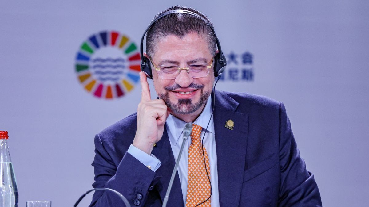 President of Costa Rica, Rodrigo Chaves Robles, smiles and points finger up while listening to interpreter headphones during the opening of the Third United Nations Ocean Conference in Nice. 