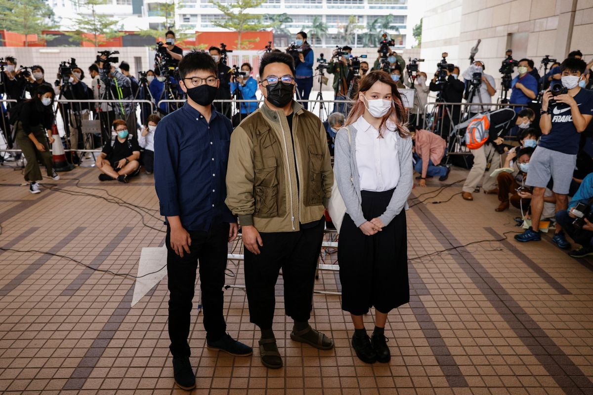 Pro-democracy activists Ivan Lam, Joshua Wong and Agnes Chow arrive at the West Kowloon Magistrates' Courts to face charges related to illegal assembly stemming from 2019, in Hong Kong, China November 23, 2020