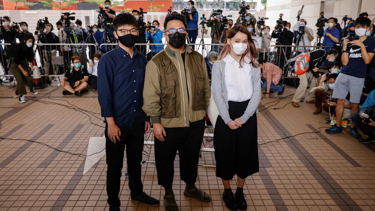 Pro-democracy activists Ivan Lam, Joshua Wong and Agnes Chow arrive at the West Kowloon Magistrates' Courts to face charges related to illegal assembly stemming from 2019, in Hong Kong, China November 23, 2020