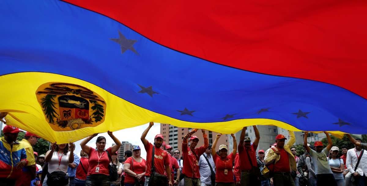 ​Pro-government supporters holding a Venezuela's flag attend a rally against U.S President Donald Trump in Caracas, Venezuela August 14, 2017. 