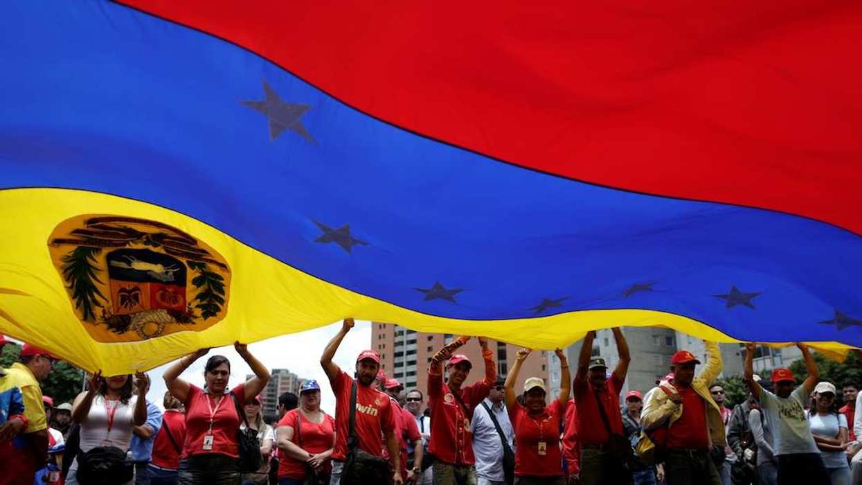 Pro-government supporters holding a Venezuela's flag attend a rally against U.S President Donald Trump in Caracas, Venezuela August 14, 2017.