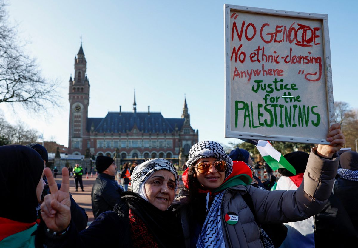 Pro-Palestinian protesters pose for a photo in front of the International Court of Justice.
