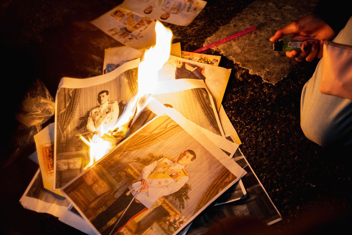 Protesters burn images of the Thai royal family 
