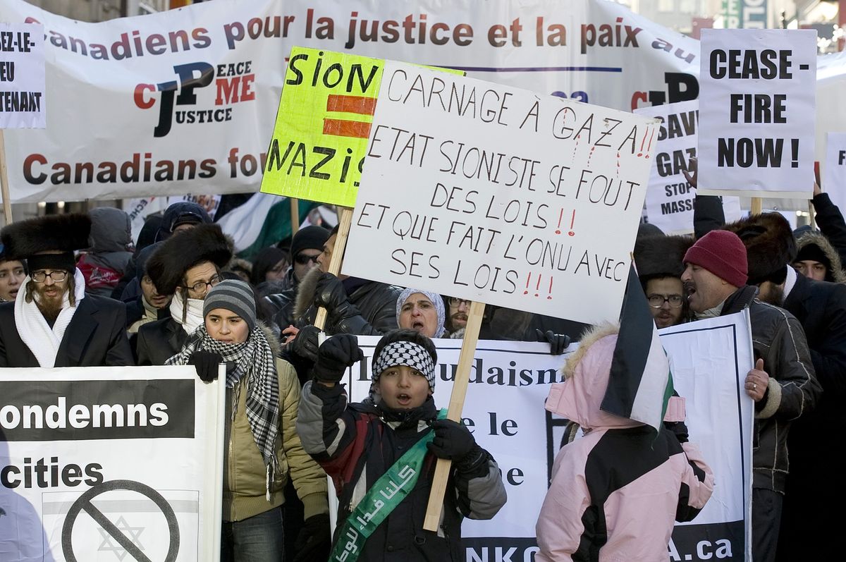 ​Protesters carry signs during a march calling for the end of the Israeli attacks in Gaza in downtown Montreal. 