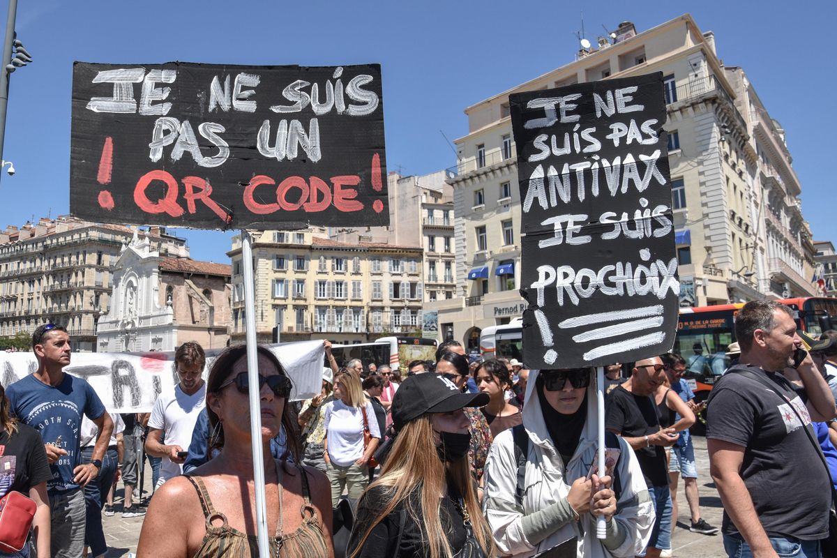 Protesters hold placards during the demonstration against the health pass in Marseille. More than 4,000 people in Marseille demonstrated against a "health pass" that French President Emmanuel Macron announced among the new anti-Covid 19 measures which will be necessary to be frequenting café terraces, restaurants, cinemas, theatres and other culture and leisure activities to help contain the spread of the Covid-19 virus.
