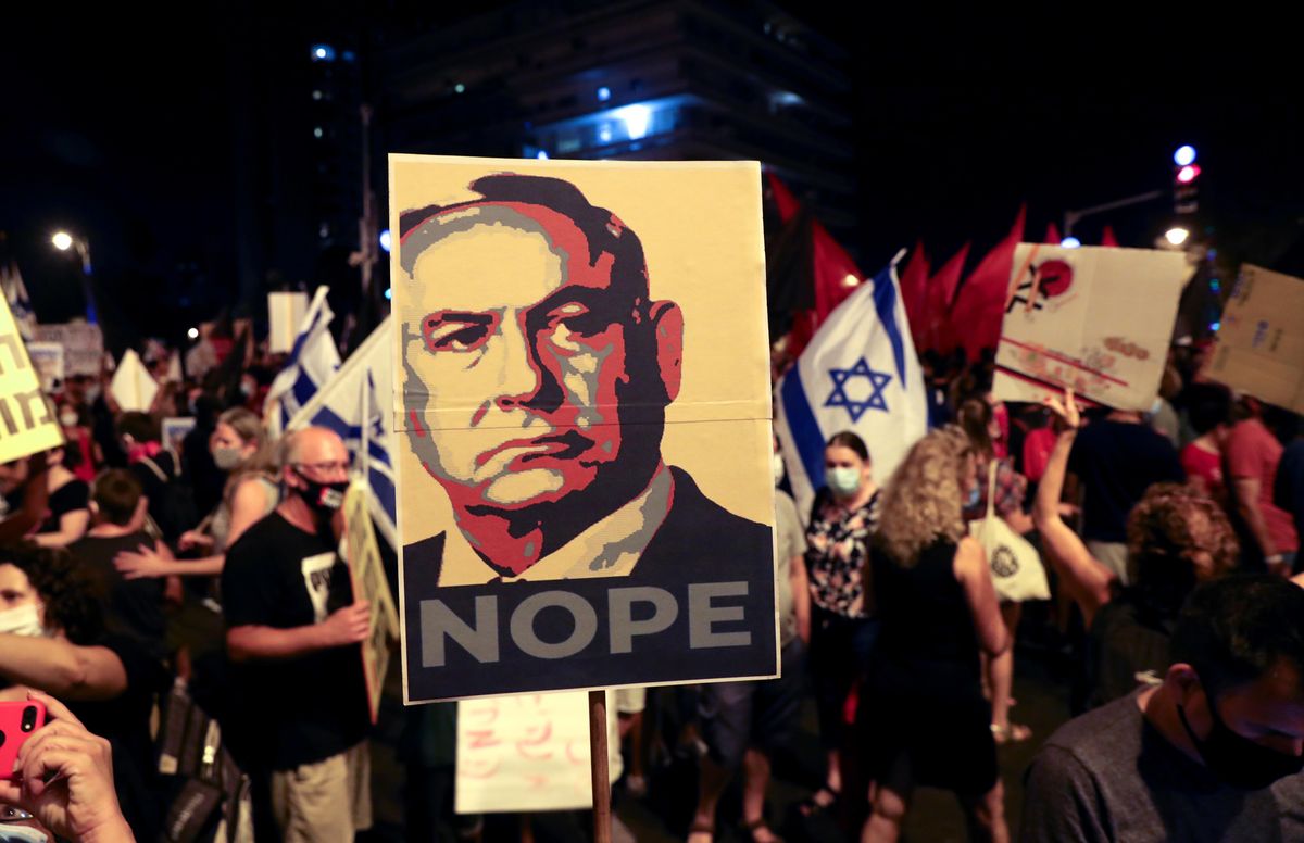 Protesters holding an image of Israel's Prime Minister Benjamin Netanyahu pasted with the slogan "NOPE"