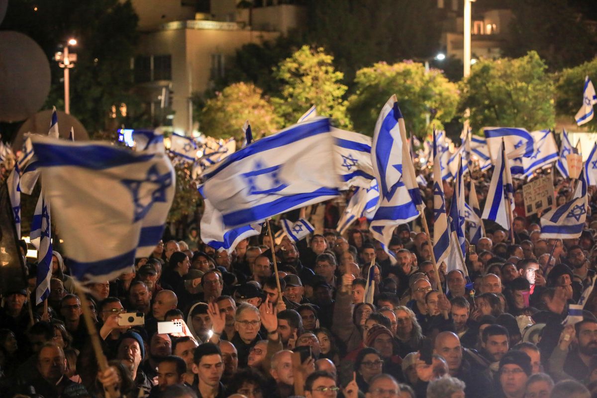 Protesters wave flags during a demonstration in Tel Aviv. 