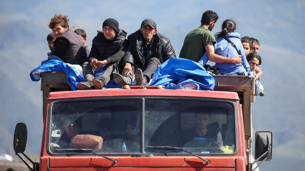 Refugees from Nagorno-Karabakh region ride in a truck upon their arrival at the border village of Kornidzor, Armenia, September 27, 2023.