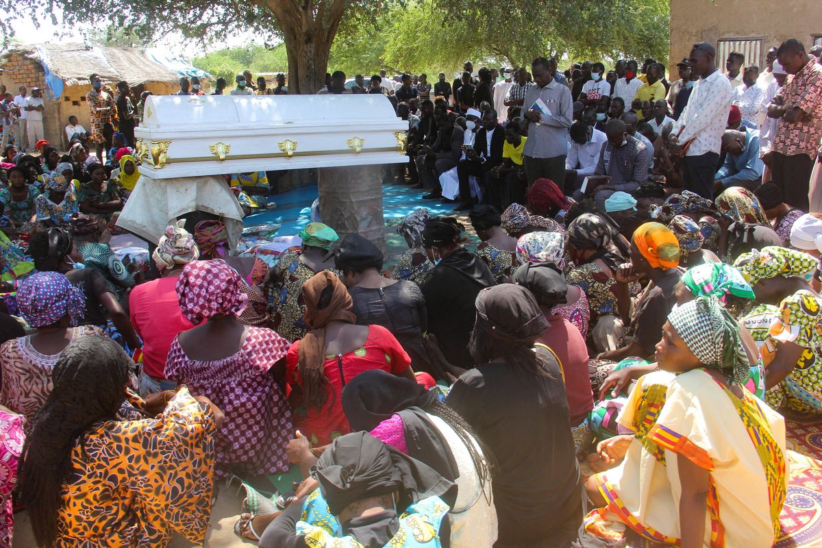 Relatives and friends gather around a Chadian journalist who was killed during a pro-democracy demonstration, as they attend his burial ceremony in N'Djamena, Chad.