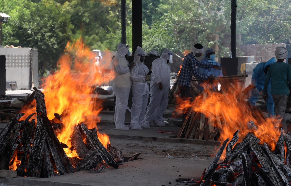 Relatives of coronavirus (Covid-19) victims perform the last rites during a cremation at Mangolpuri crematorium ground in New Delhi.