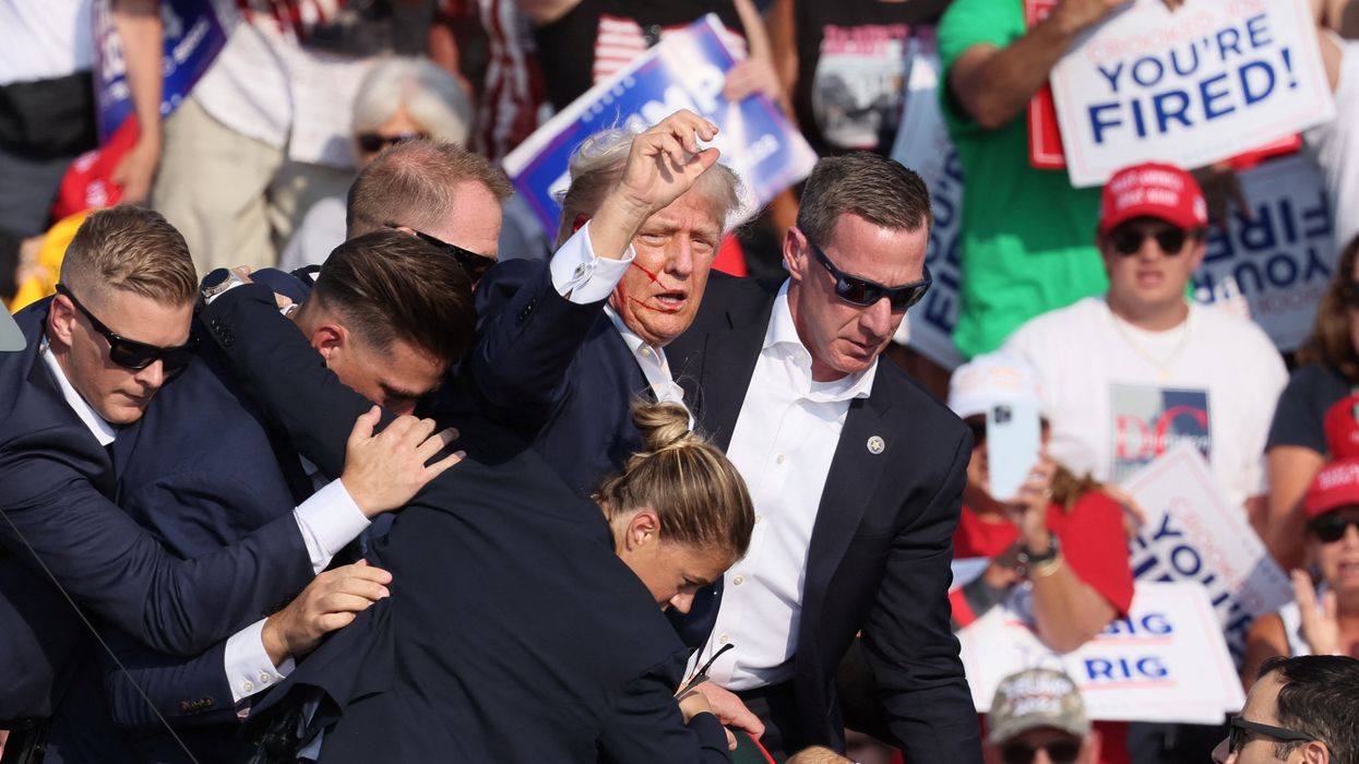 Republican presidential candidate and former U.S. President Donald Trump gestures with a bloodied face as multiple shots rang out during a campaign rally at the Butler Farm Show in Butler, Pennsylvania, U.S., July 13, 2024.