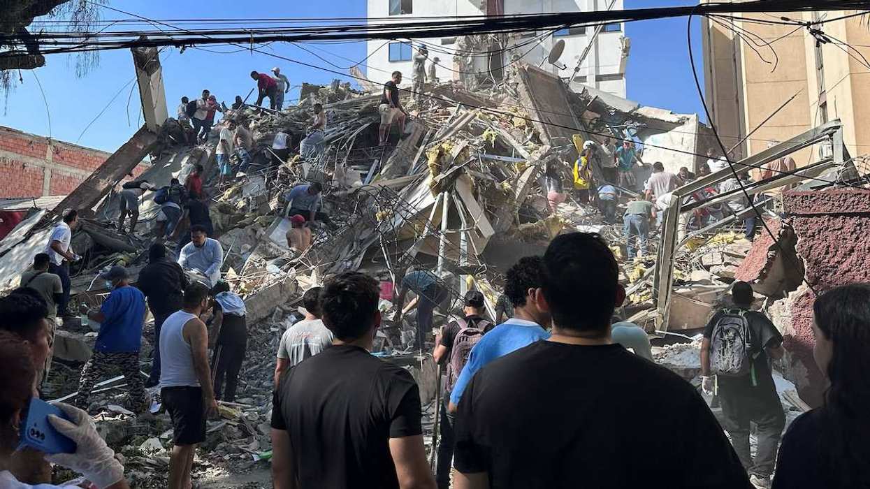Residents dig through the debris of a collapsed building after an earthquake.