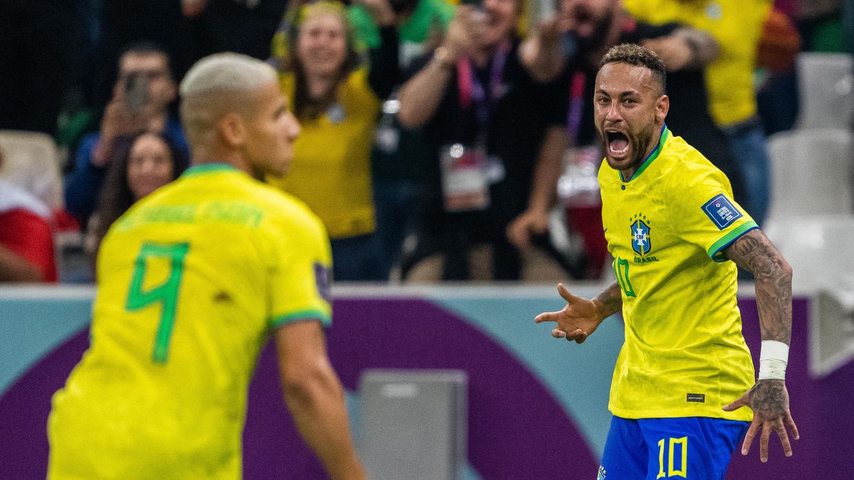 Richarlison (L) and Neymar (R) of Brazil celebrate after scoring the first goal during the FIFA World Cup 2022 match against Serbia in Doha.
