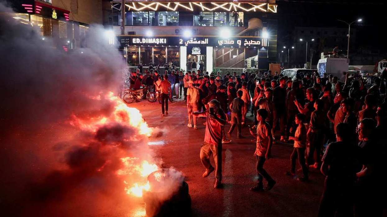 rotesters burn tyres and block the road in protest against rising fuel prices on the highway between Aleppo and Turkey, Syria.