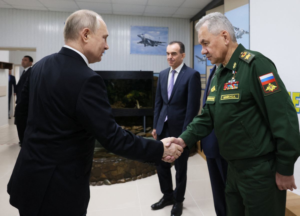 ​Russian President Vladimir Putin shakes hands with Defence Minister Sergei Shoigu
