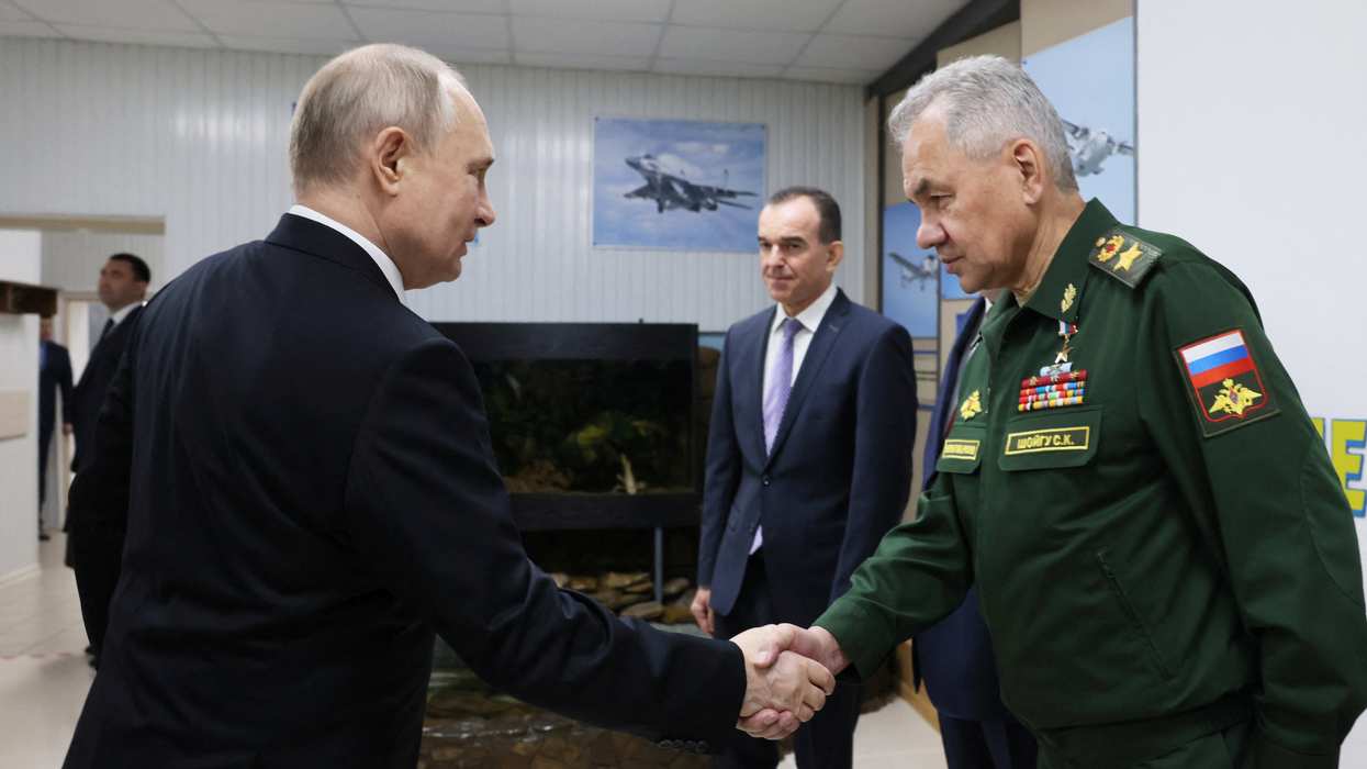 Russian President Vladimir Putin shakes hands with Defence Minister Sergei Shoigu