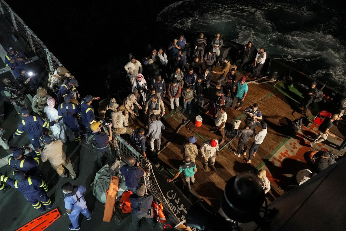 Saudi navy officials help civilians onboard their ship to be evacuated from Sudan.