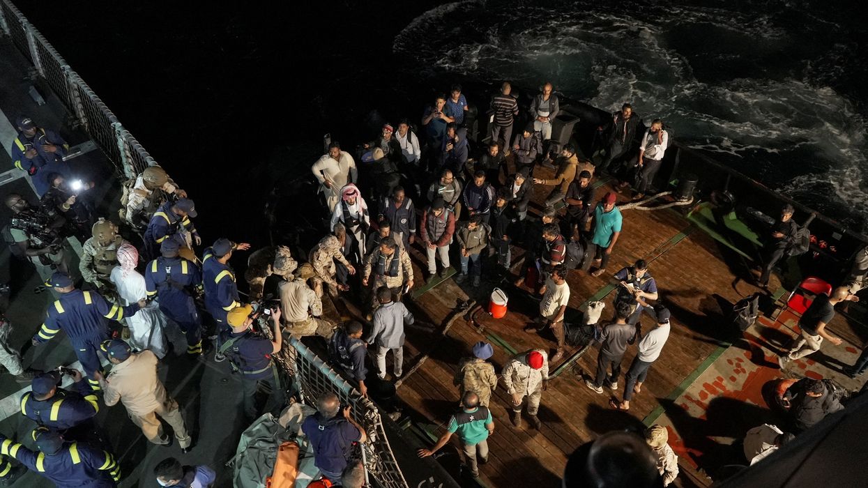 Saudi navy officials help civilians onboard their ship to be evacuated from Sudan.