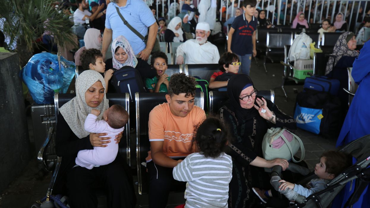 Scores of foreign passport holders trapped in Gaza started leaving the war-torn Palestinian territory on Nov. 1 -- some are seen here waiting at the Rafah border crossing in the southern Gaza Strip before crossing into Egypt.