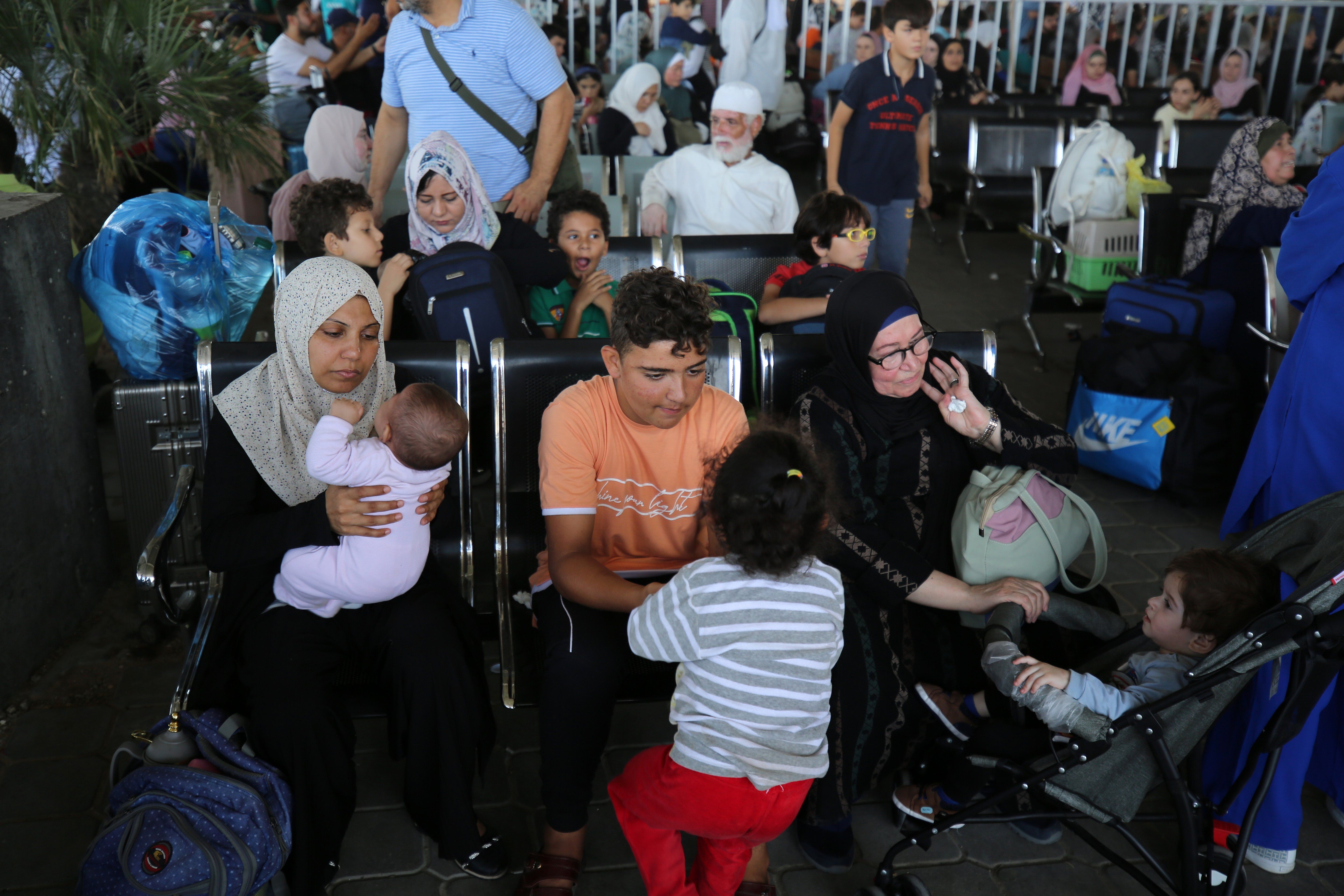 Scores of foreign passport holders trapped in Gaza started leaving the war-torn Palestinian territory on Nov. 1 -- some are seen here waiting at the Rafah border crossing in the southern Gaza Strip before crossing into Egypt.