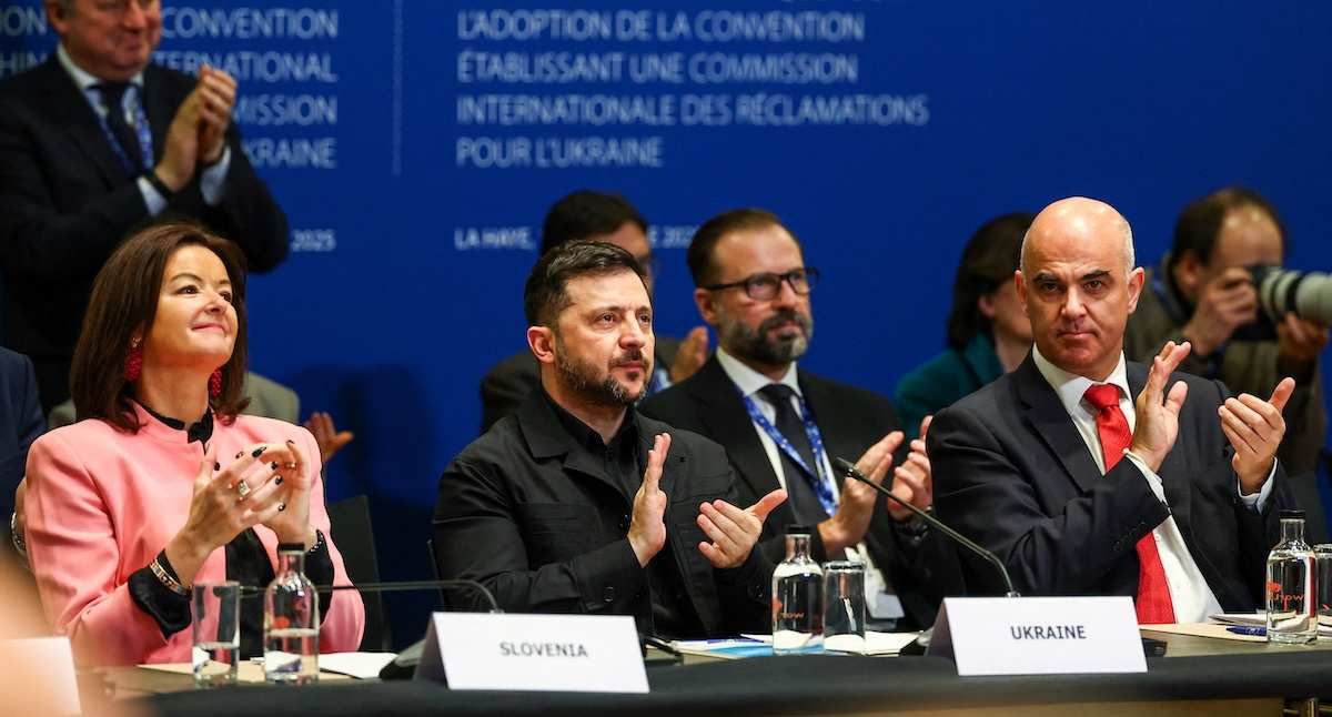 Slovenia's Foreign Minister Tanja Fajon, Ukrainian President Volodymyr Zelenskiy and Secretary General of the Council of Europe Alain Berset applaud during a Council of Europe diplomatic conference in The Hague, Netherlands, December 16, 2025.