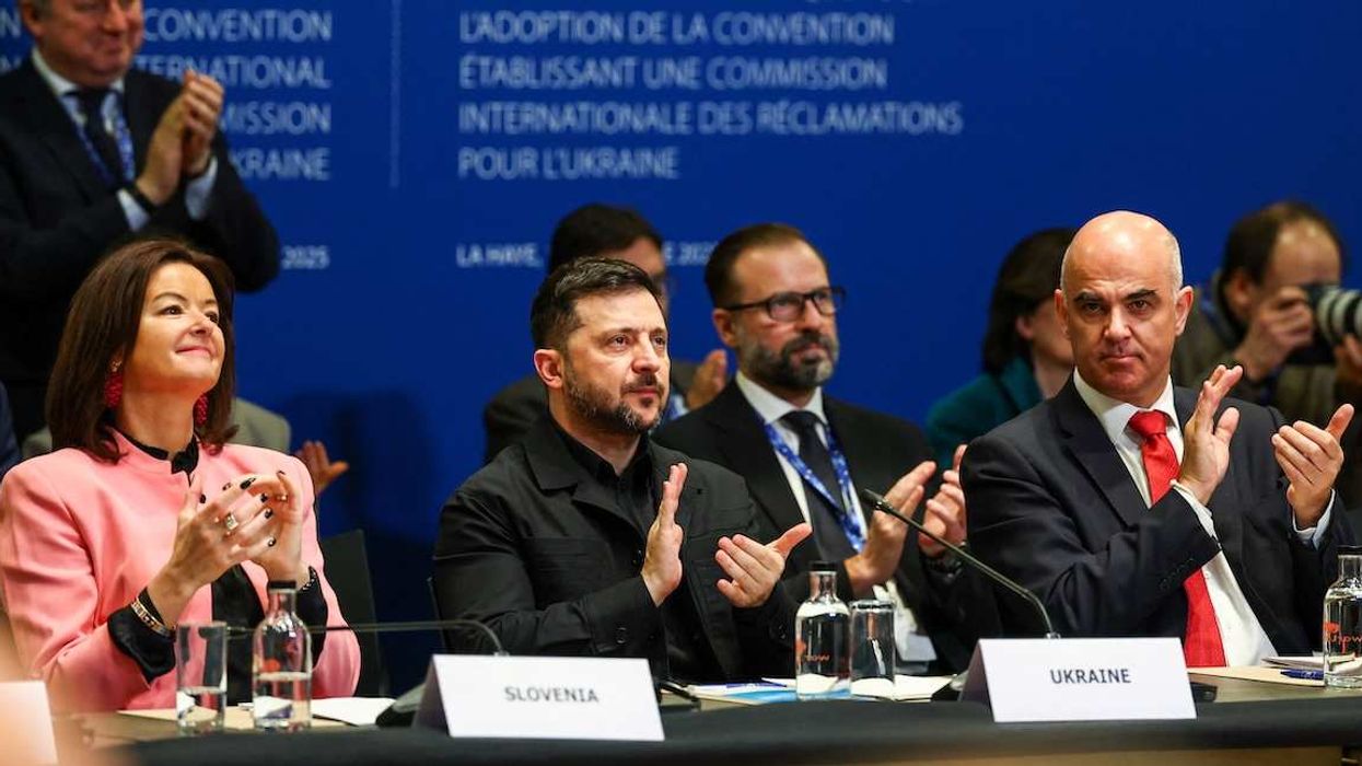 Slovenia's Foreign Minister Tanja Fajon, Ukrainian President Volodymyr Zelenskiy and Secretary General of the Council of Europe Alain Berset applaud during a Council of Europe diplomatic conference in The Hague, Netherlands, December 16, 2025.