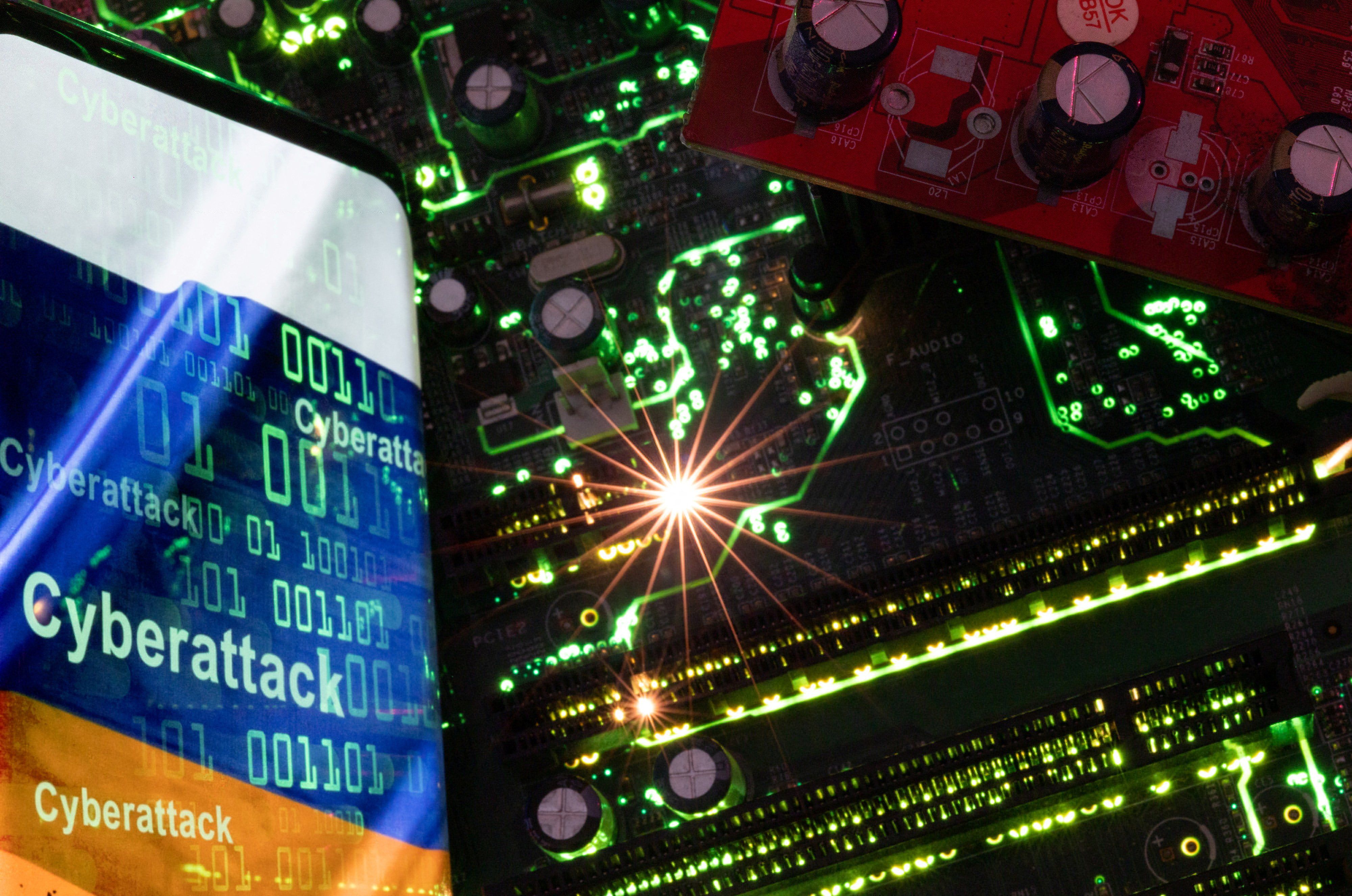 Smartphone with a displayed Russian flag with the word "Cyberattack" and binary codes over it is placed on a computer motherboard in this illustration.