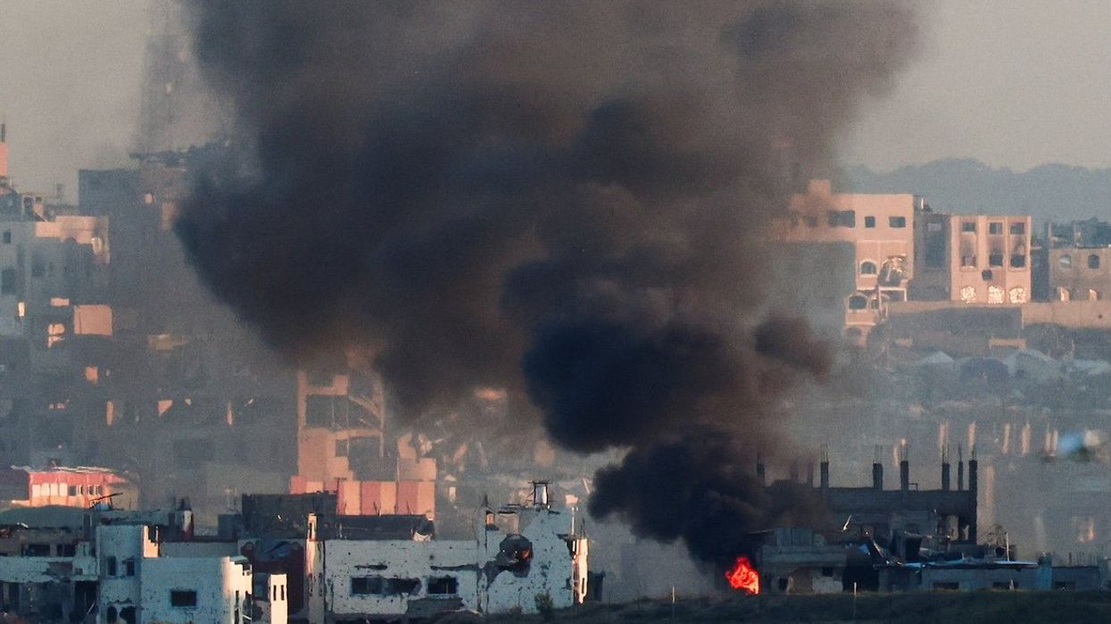 Smoke rises from a burning building in North Gaza, as seen from the Israel-Gaza border, March 23, 2025.