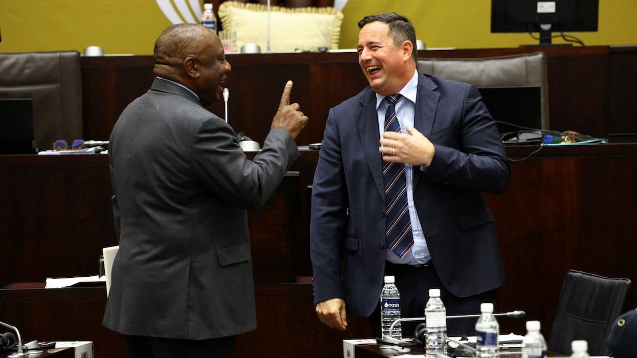 South African President Cyril Ramaphosa interacts with the leader of the opposition party, John Steenhuisen ahead of National Assembly members' questions in parliament in Cape Town, South Africa, November 3, 2022.