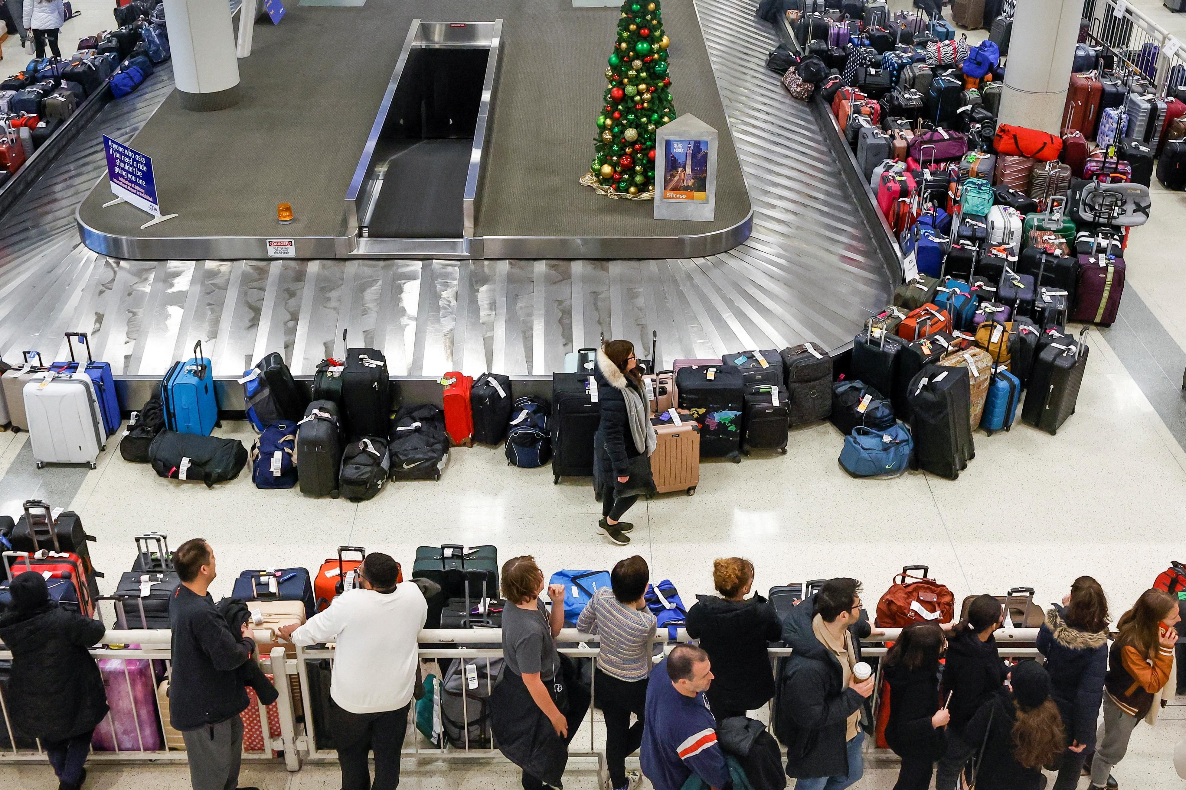 Southwest Airlines travelers looks for their baggage in a pile of lost suitcases at Chicago Midway International Airport.