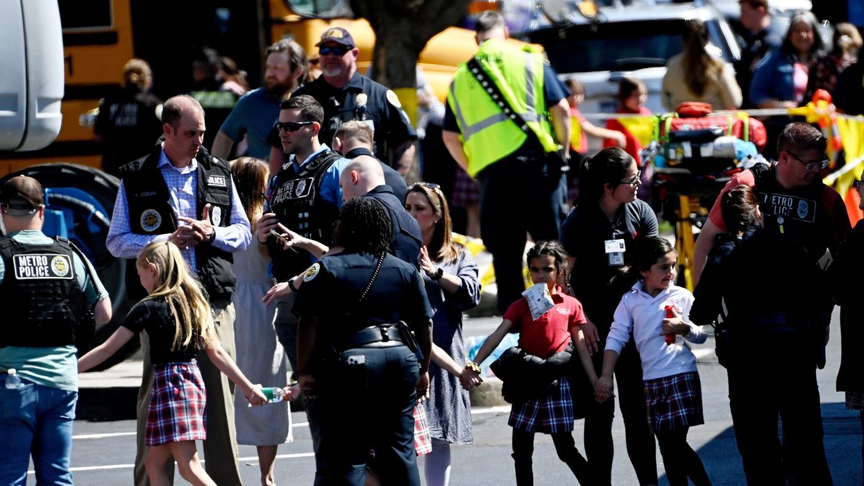 Students from the Covenant School in Nashville, Tenn., hold hands after getting off a bus to meet their parents at the reunification site following a mass shooting.