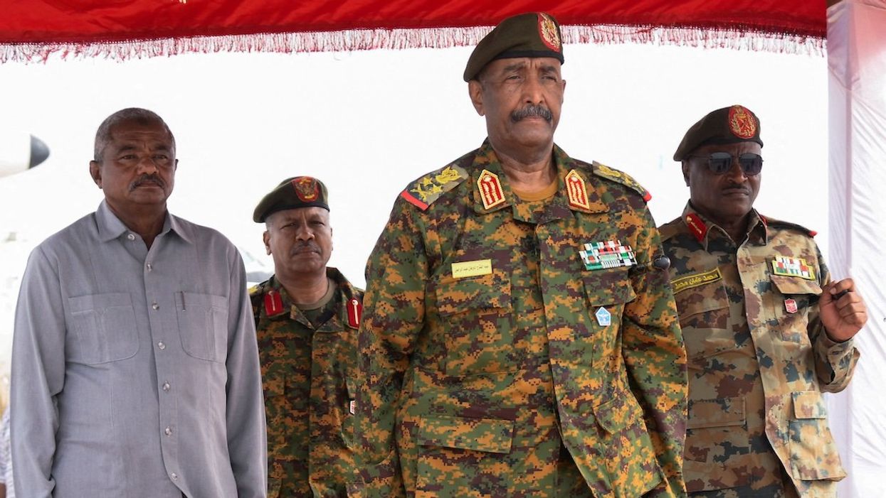 Sudan's General Abdel Fattah al-Burhan listens to the national anthem after landing in the military airport in the city of Port Sudan, Sudan, August 27, 2023.