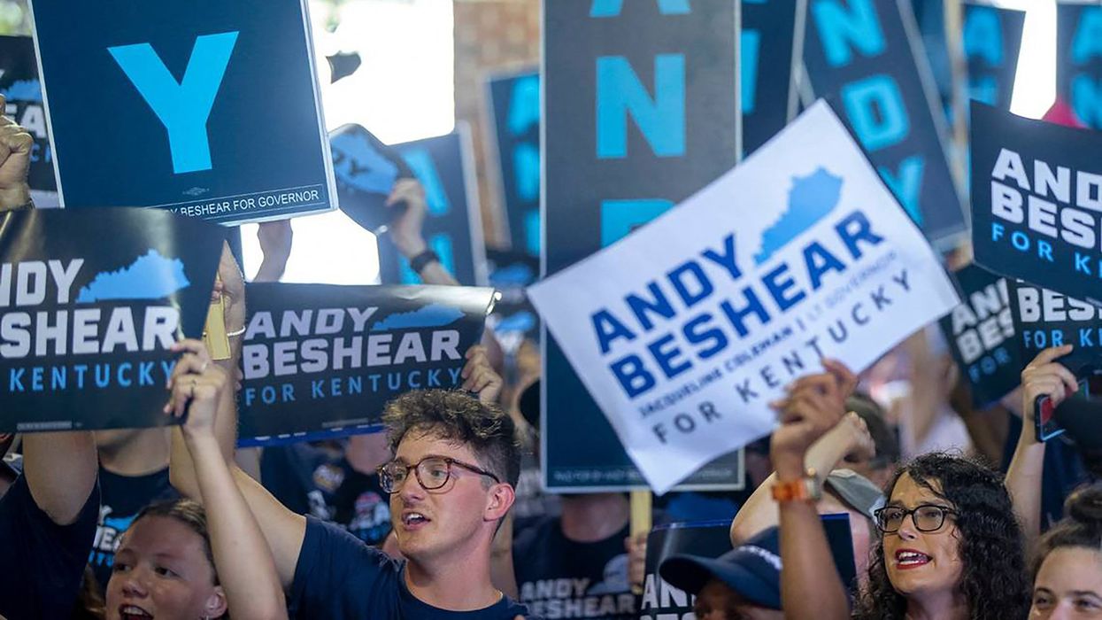 Supporters of Kentucky Gov. Andy Beshear hold signs and cheer during the annual St. Jerome Fancy Farm Picnic in Fancy Farm, Kentucky, on Aug. 5, 2023.
